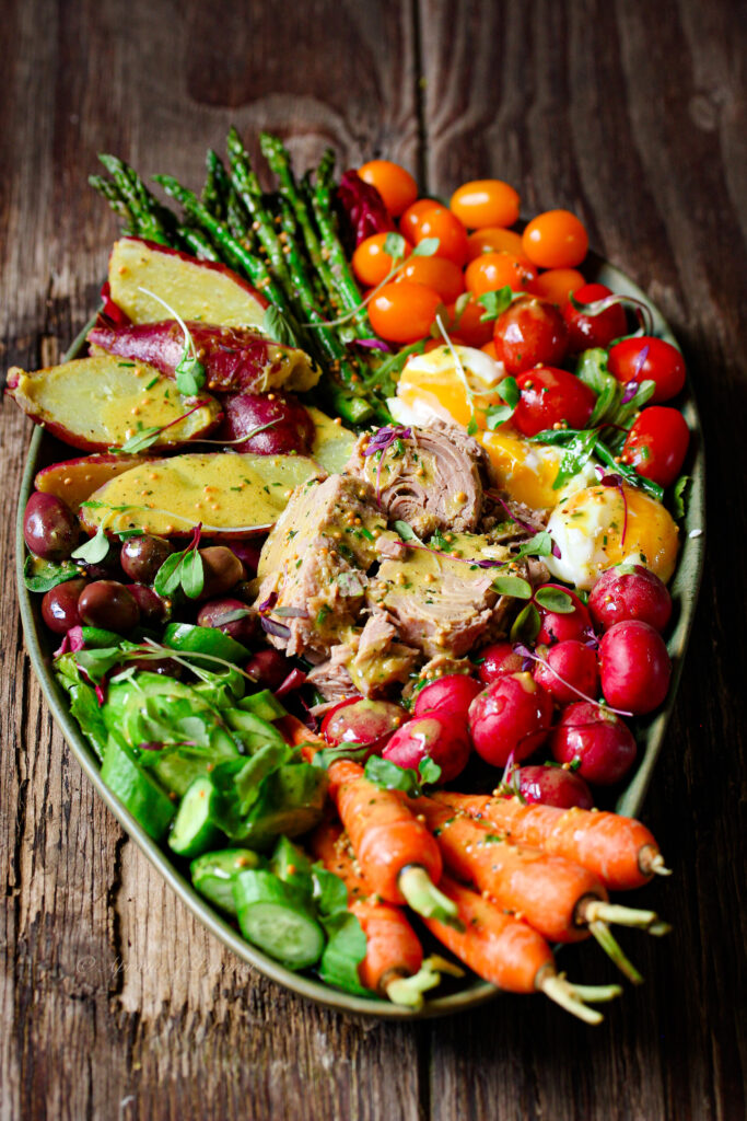 Colourful tuna Nicoise Salad with baby potatoes, cherry tomatoes, olives and eggs.PriMade Food