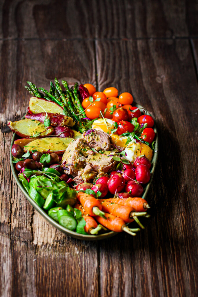 Colourful tuna Nicoise Salad with baby potatoes, cherry tomatoes, olives and eggs.PriMade Food